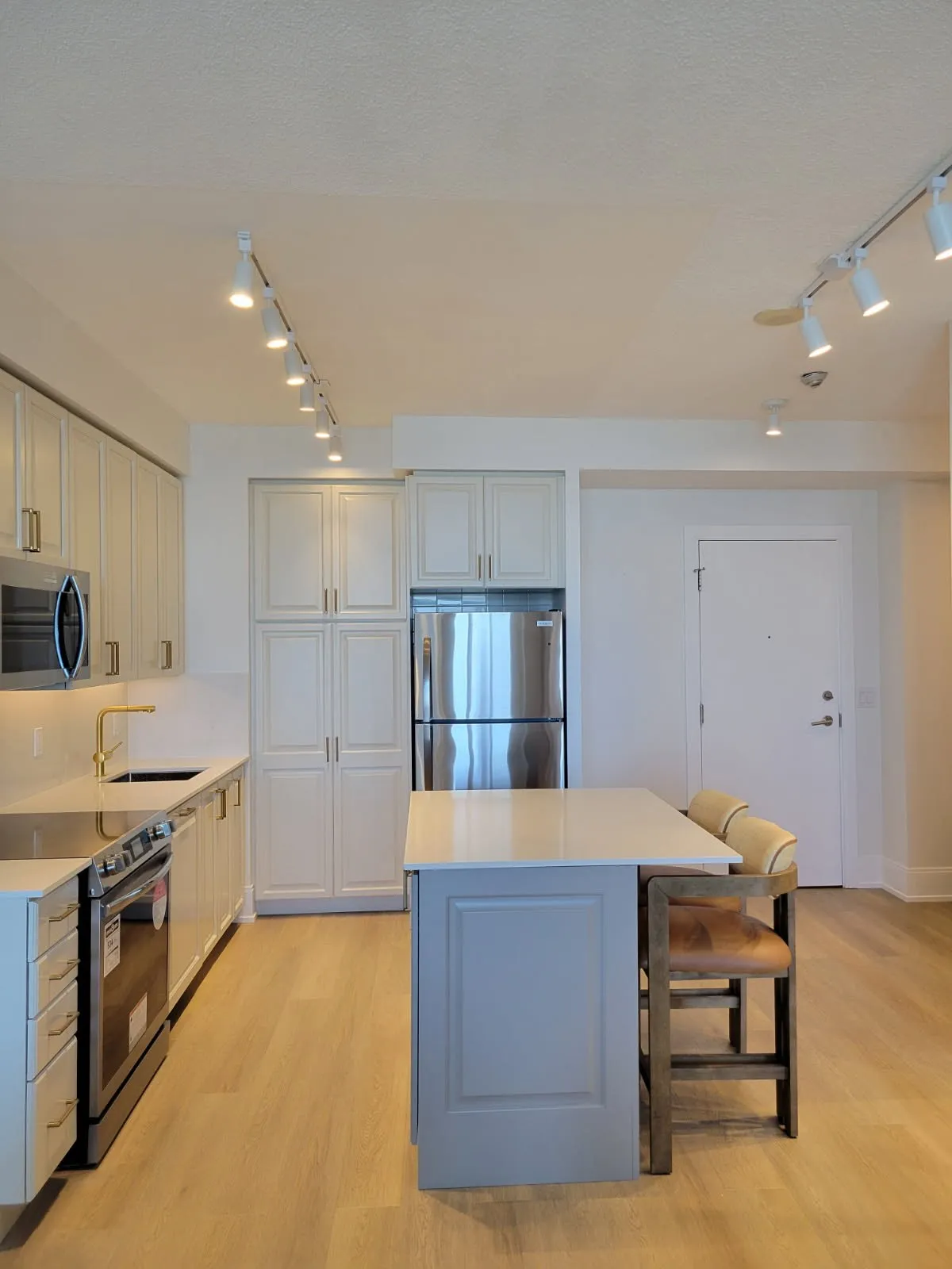 After — espresso repainted cream, island extended and finished in a second colour — City Centre, Mississauga