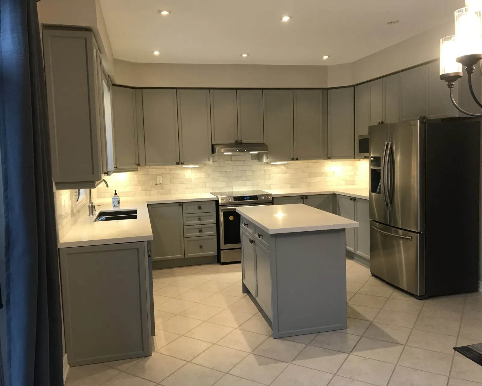 A kitchen sprayed soft grey, the island, layout and counters unchanged