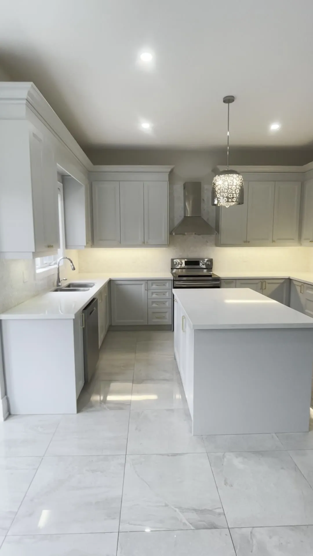 A finished refaced kitchen in the GTA — light grey shaker doors and drawer fronts on the original boxes, quartz counters and a matching island