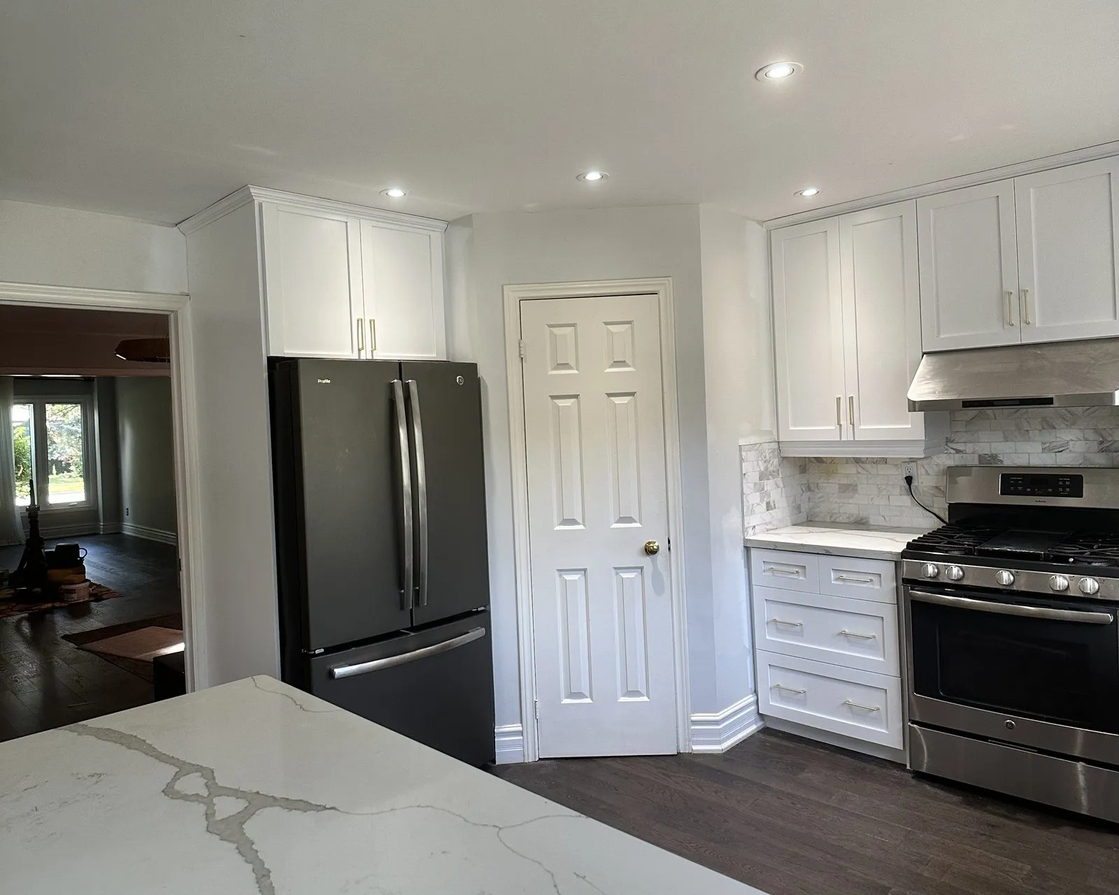 A new veined stone counter running into a finished kitchen, templated after the new cabinet fronts were fitted and left to settle