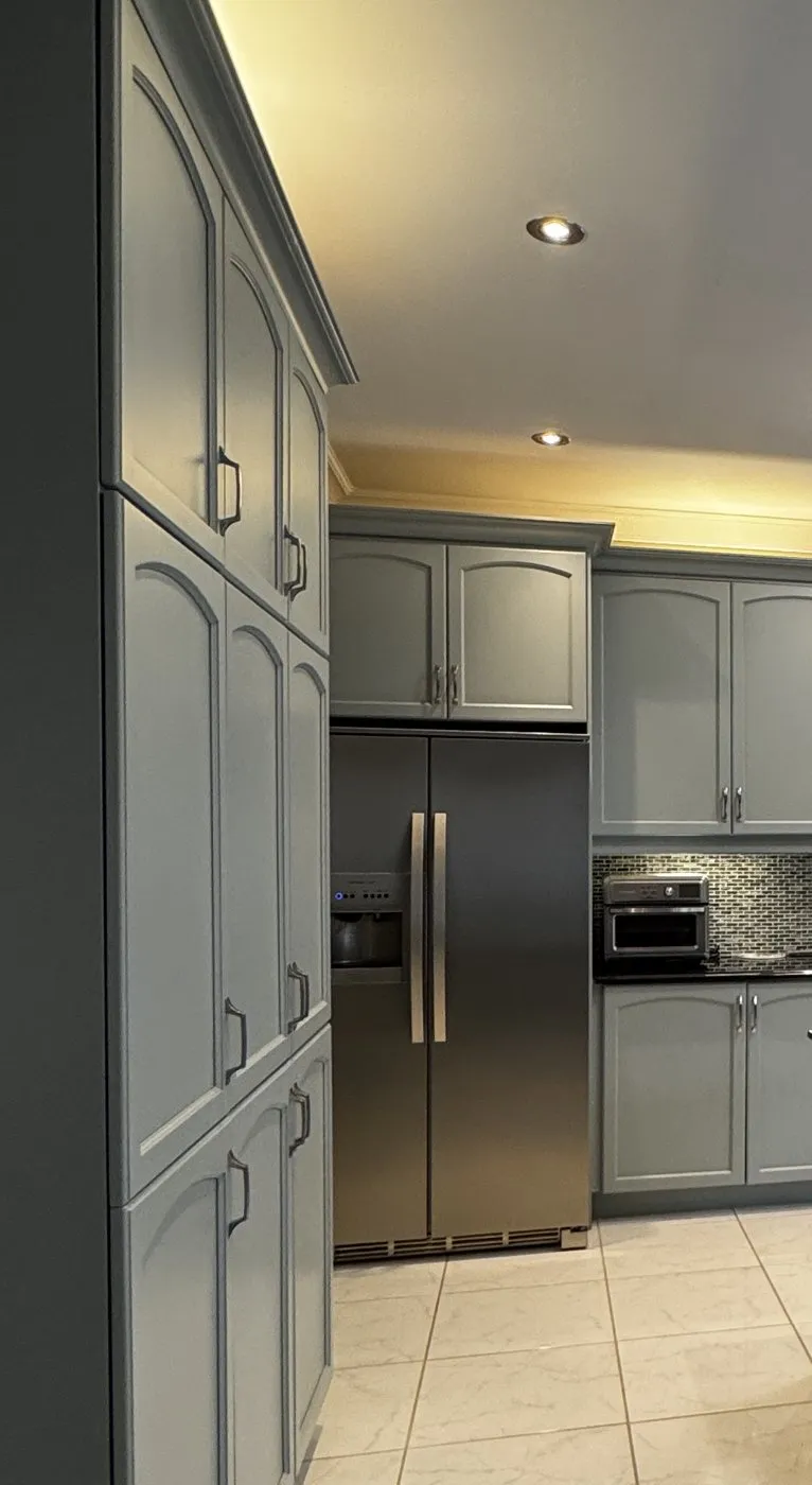 Tall pantry and upper cabinets in Boothbay Gray with arched doors and brushed nickel pulls