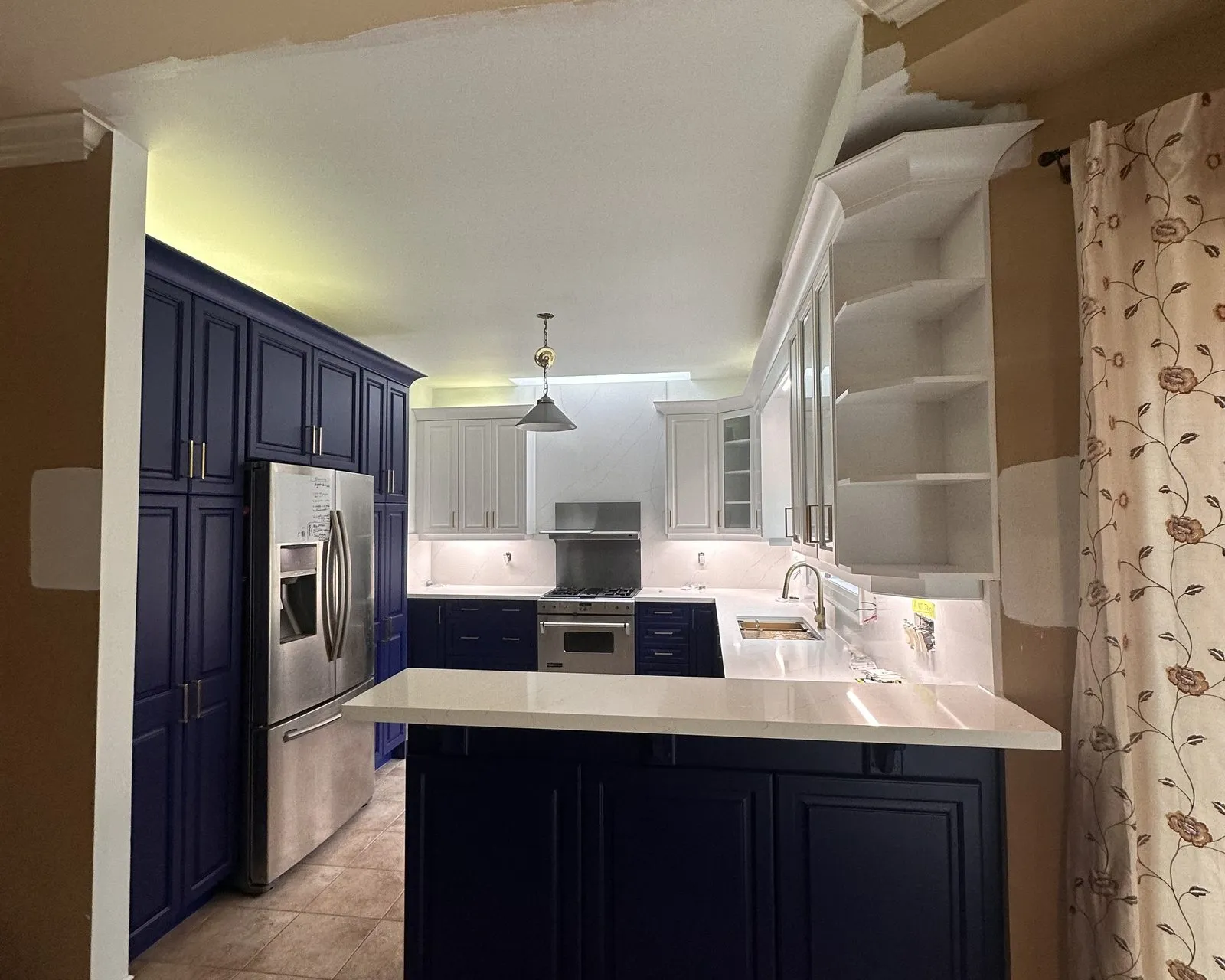 After — honey maple sprayed navy below and white above, counters by others — Merton, Oakville