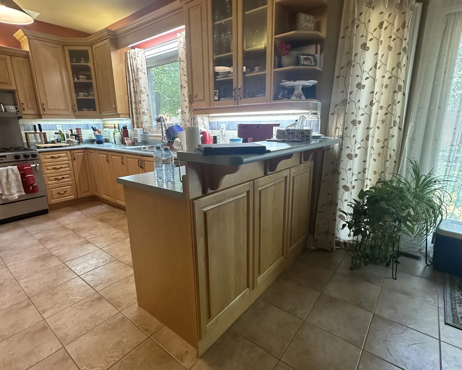 Before — honey maple sprayed navy below and white above, counters by others — Merton, Oakville