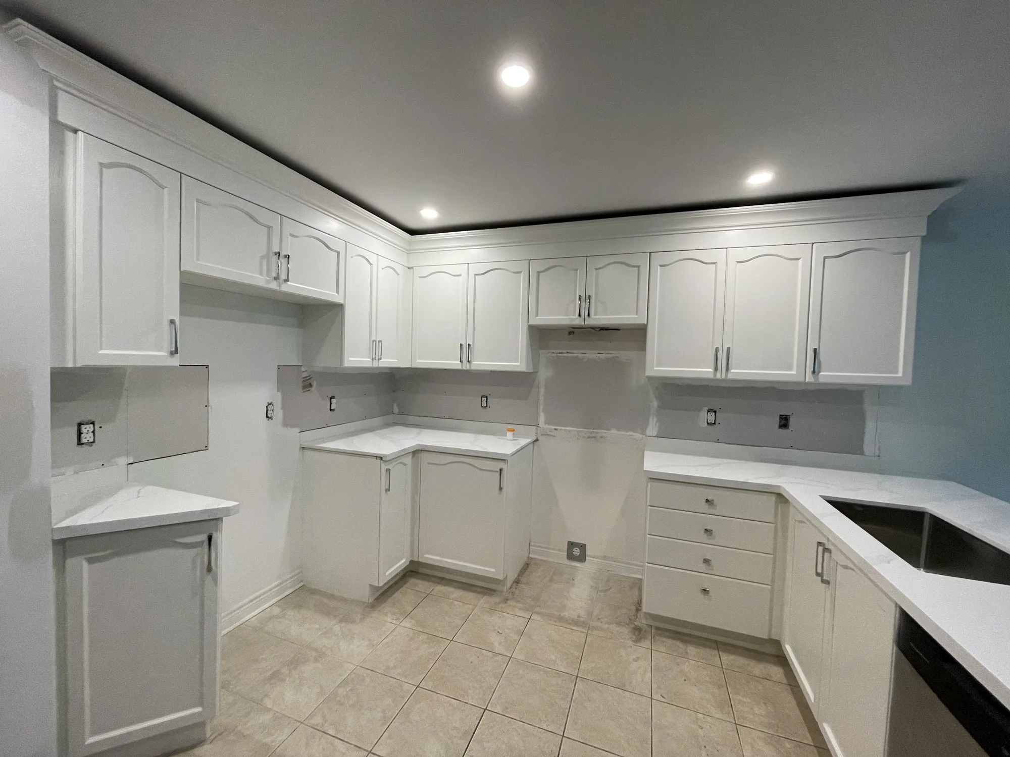 After — whitewashed oak refinished white, crown moulding added, new quartz and sinks — Rouge Woods, Richmond Hill