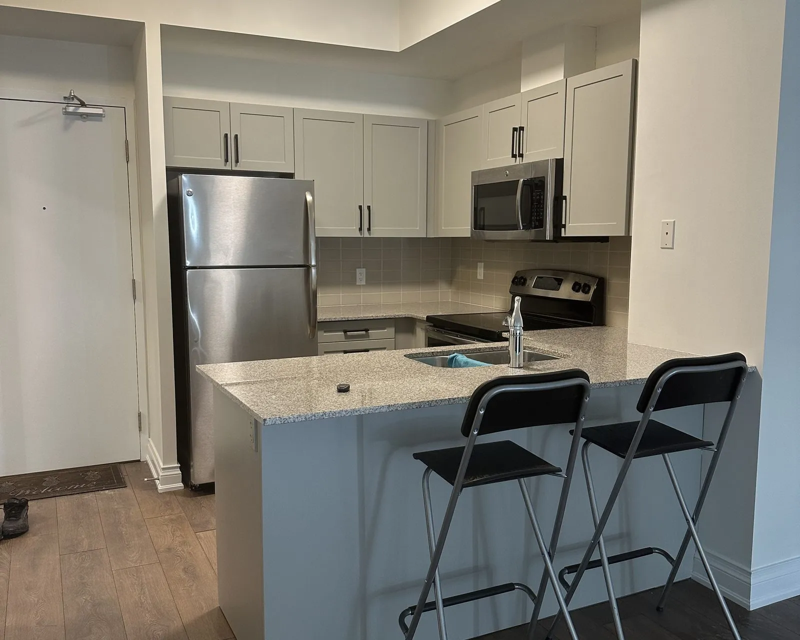After — espresso thermofoil to Cashmere Grey, refaced and sprayed to match — Markham Village, Markham