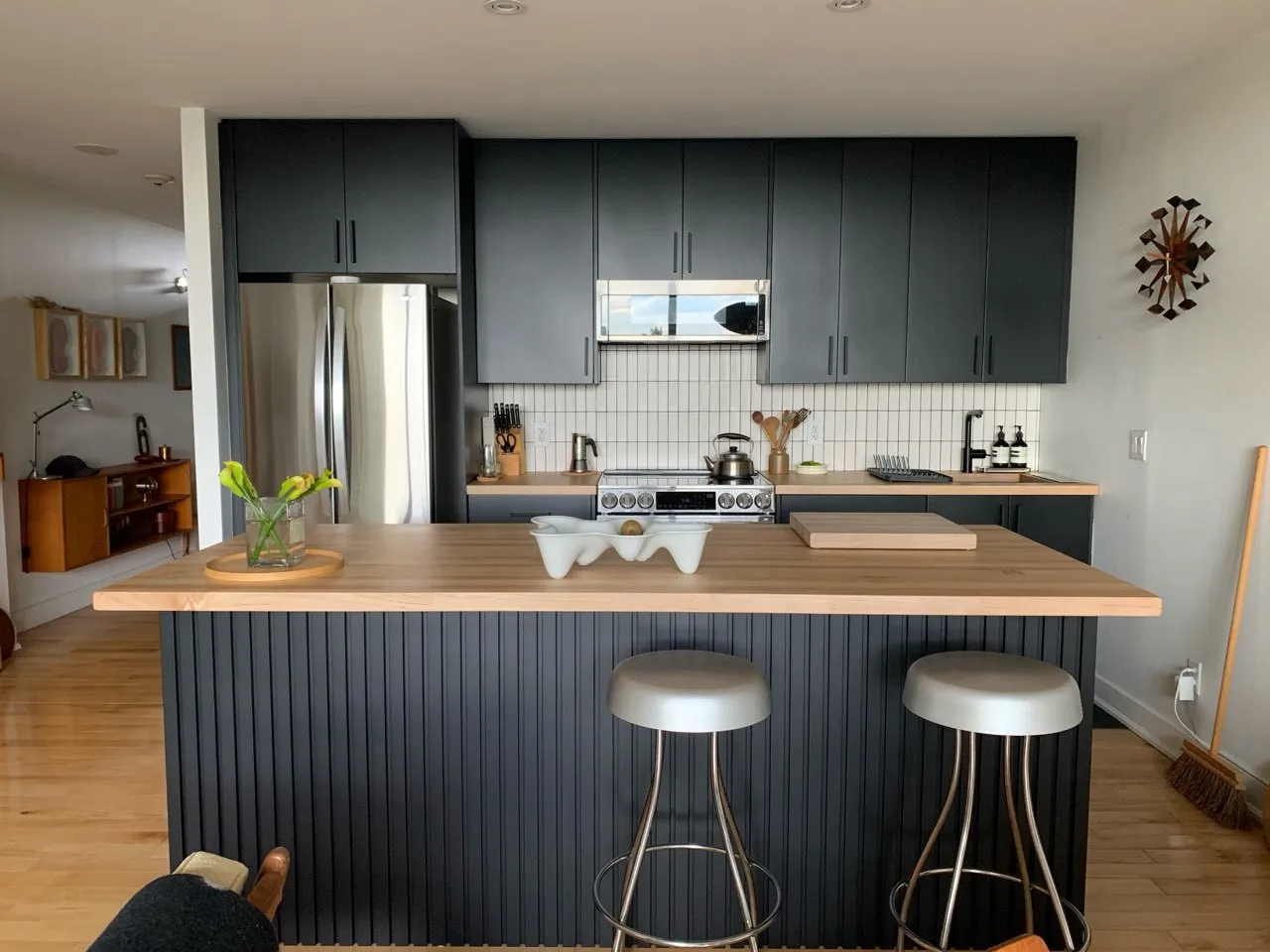 A Toronto kitchen by Kitchen Made New with charcoal slab doors, a fluted island panel and a butcher-block countertop