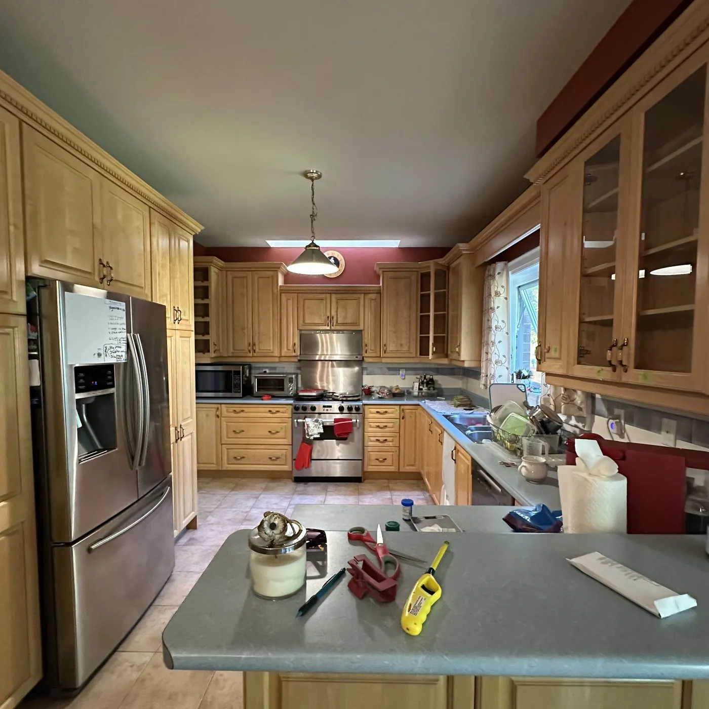 Before — Kitchen cabinet painting in Merton, Oakville — maple cabinetry sprayed navy below and white above, the boxes and layout unchanged