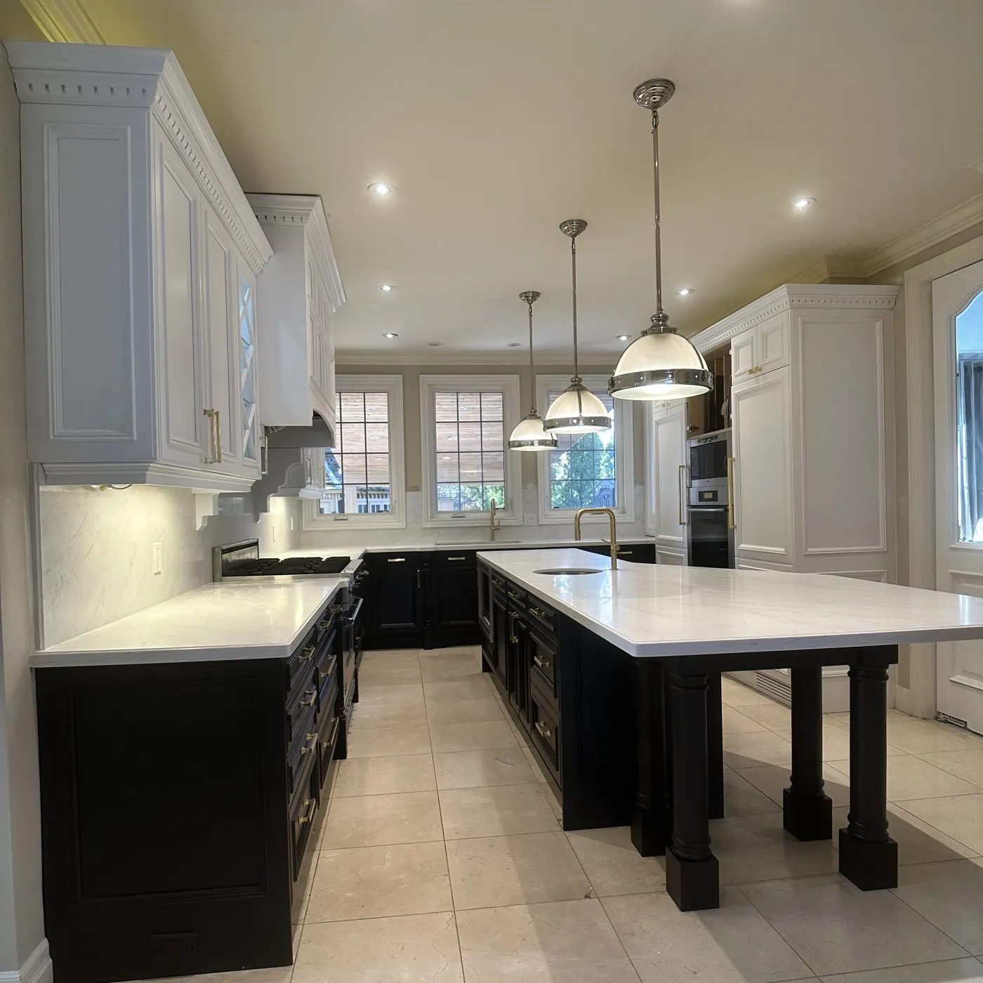 Quartz countertop replacement in Ford, Oakville — dark granite replaced with white quartz, the cabinets sprayed white over black in the same project